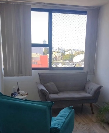 Sala de atendimento do consultório, com sofá e poltrona em ambiente iluminado