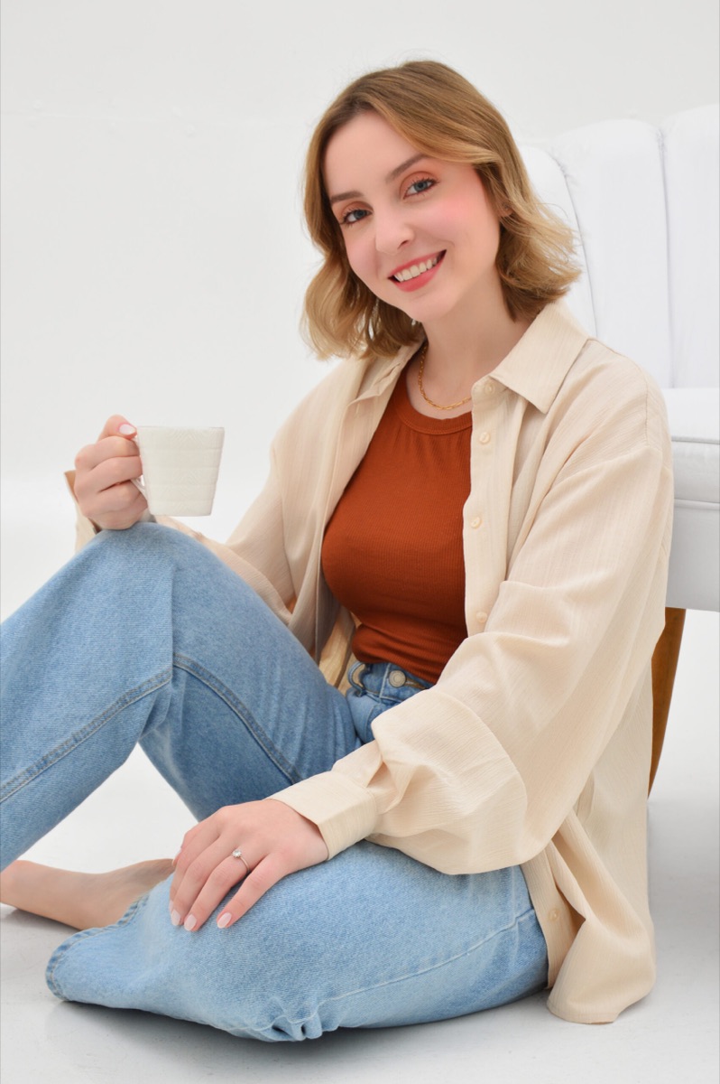 Gabriela Bobsin Cerentini, psicóloga, sorrindo com uma xícara de café